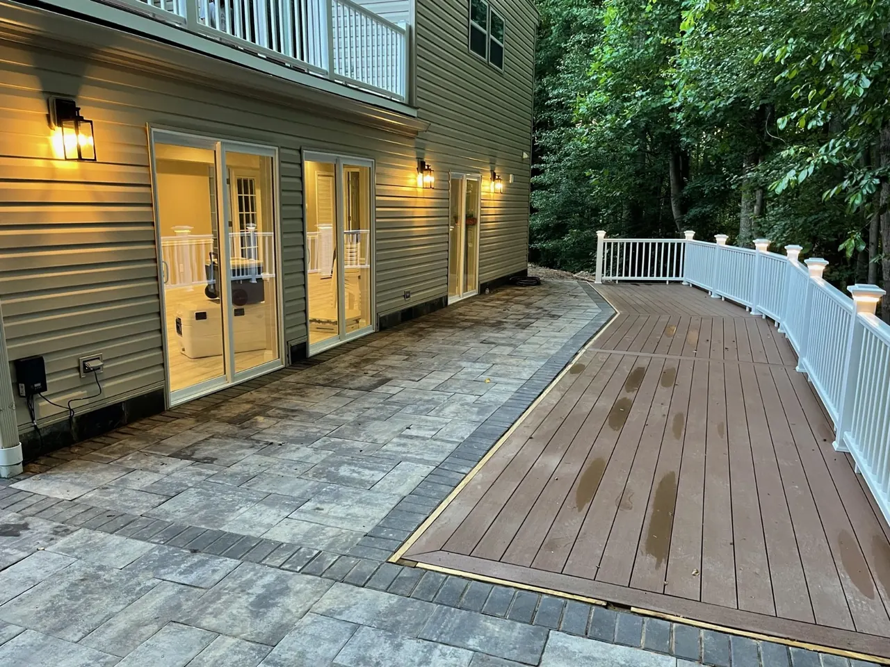 Deck + paver patio at dusk — Eagle Remodeling Services